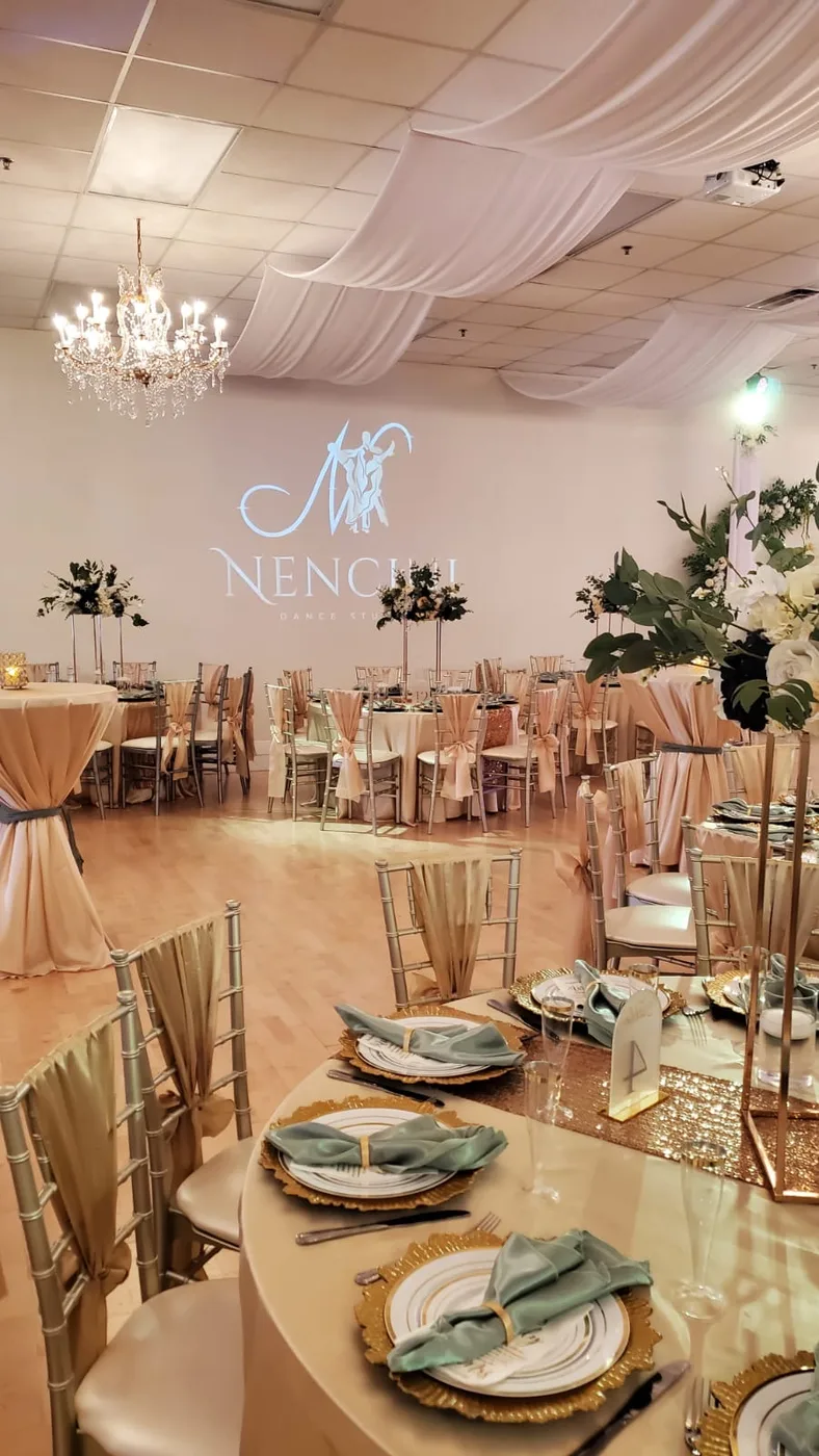 Sage and champagne reception room beneath chandeliers