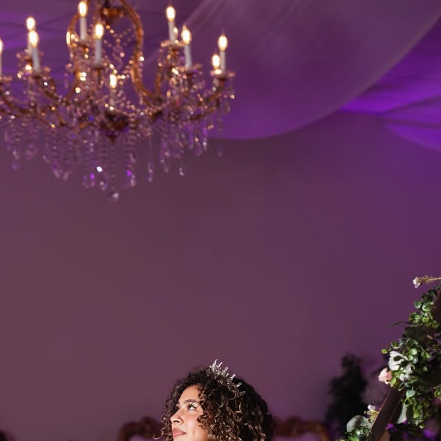 Quinceañera portrait under chandeliers from Nencini Ballroom Instagram feed
