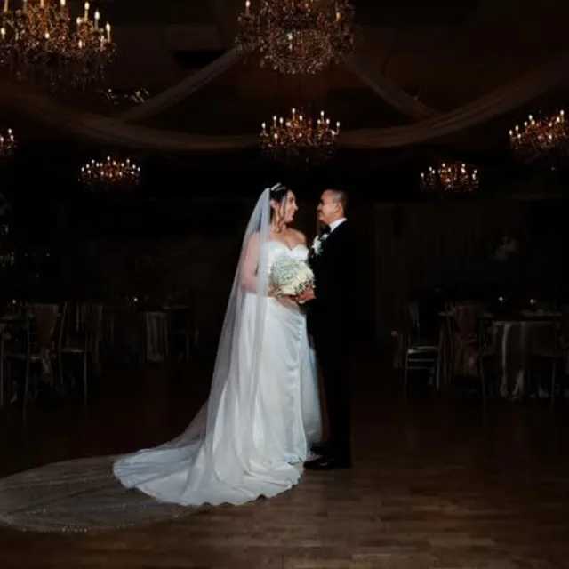 Wedding couple beneath the ballroom chandeliers